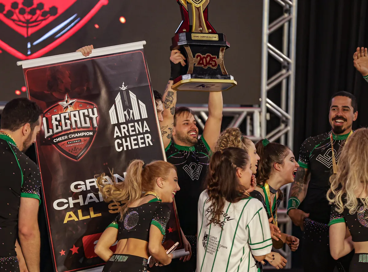 Equipe da Wolfpack erguendo o troféu e o banner de Grand Champion All Star na Legacy 2025