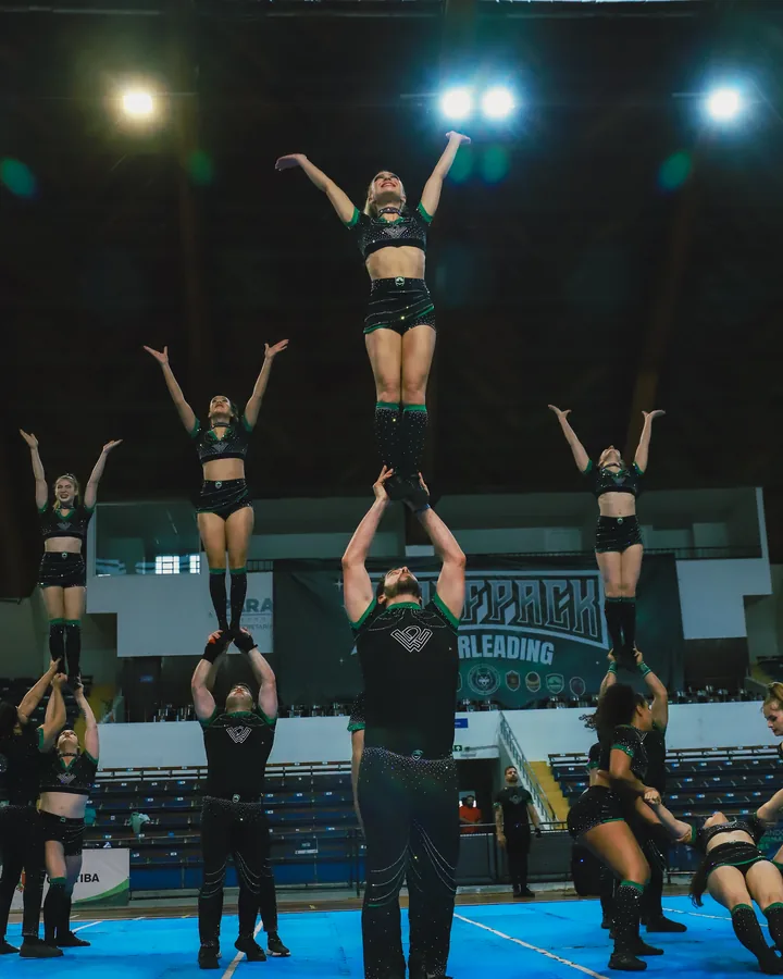 Três flyers da Wolfpack no alto de uma pirâmide, sob as luzes do Showcase 2025