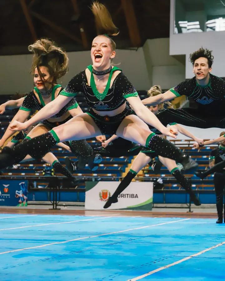 Atleta da Wolfpack no ar em um salto, no tablado do Showcase 2025
